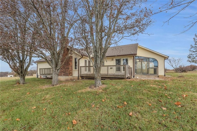 rear view of house with a lawn and a wooden deck