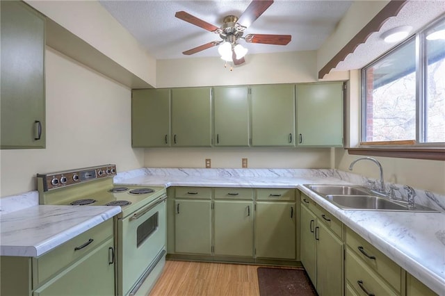 kitchen featuring white range with electric cooktop, light hardwood / wood-style flooring, sink, and green cabinetry