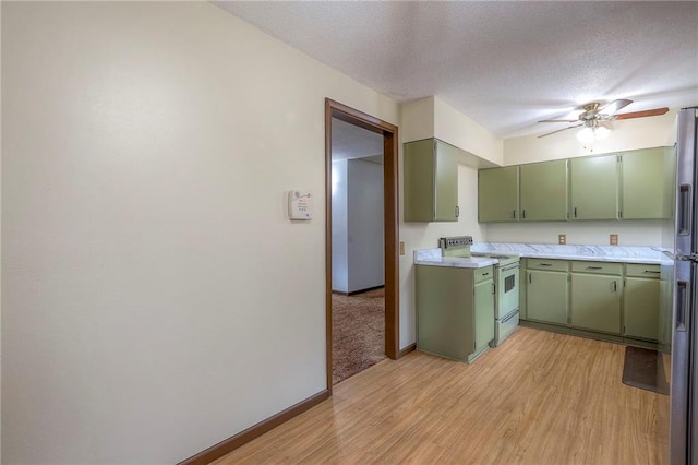 kitchen featuring a textured ceiling, white range with electric stovetop, ceiling fan, light hardwood / wood-style floors, and green cabinets