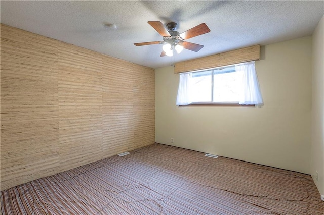 spare room with ceiling fan and a textured ceiling