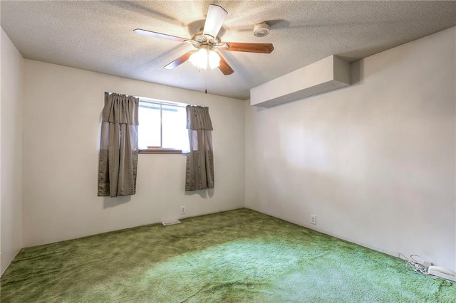 empty room with carpet flooring, ceiling fan, and a textured ceiling