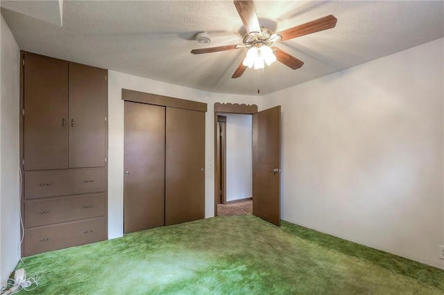 unfurnished bedroom featuring ceiling fan, carpet, and a textured ceiling