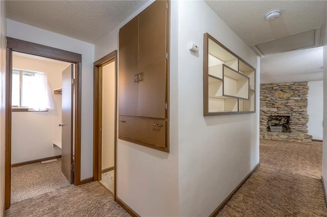 corridor featuring a textured ceiling and light carpet