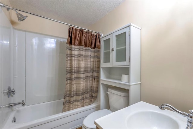 full bathroom with a textured ceiling, shower / bath combo, toilet, and sink