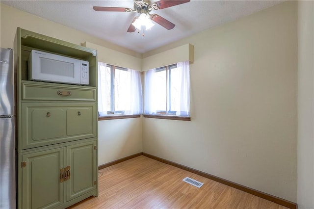 unfurnished room with light wood-type flooring and ceiling fan