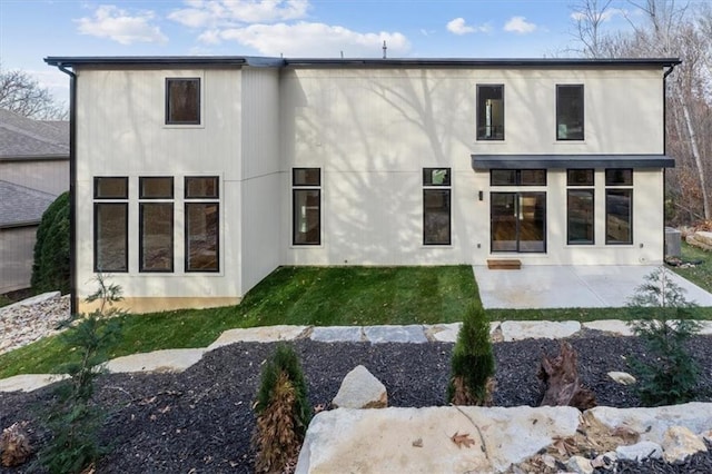 rear view of property with a yard and a patio