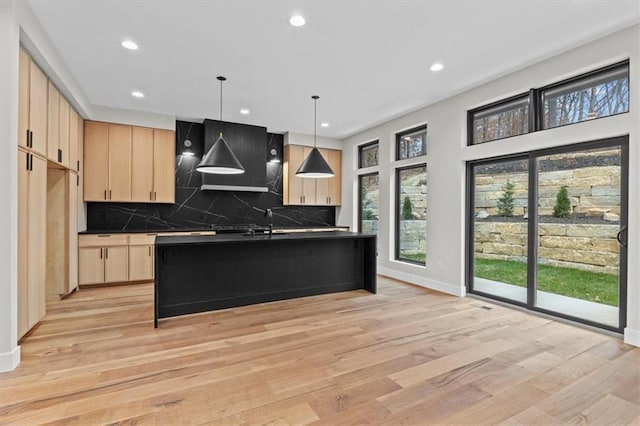 kitchen featuring decorative light fixtures, light brown cabinets, and light wood-type flooring