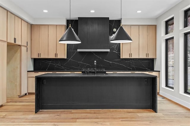 kitchen featuring tasteful backsplash, light brown cabinetry, decorative light fixtures, and light wood-type flooring