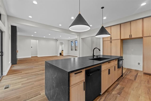 kitchen featuring light brown cabinets, sink, light wood-type flooring, and a kitchen island with sink