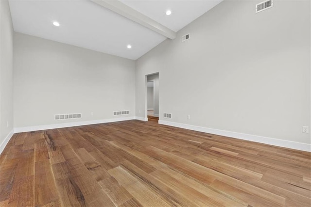 spare room with beamed ceiling, high vaulted ceiling, and wood-type flooring