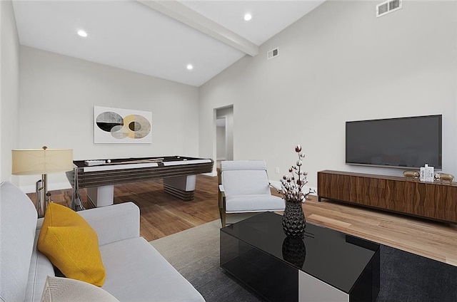 living room with beamed ceiling, hardwood / wood-style flooring, and high vaulted ceiling