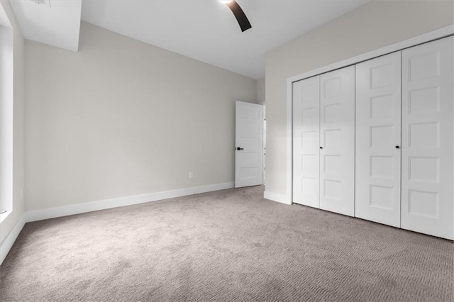 unfurnished bedroom with carpet flooring, ceiling fan, and a closet