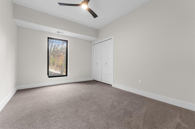 unfurnished bedroom featuring carpet flooring, ceiling fan, and a closet