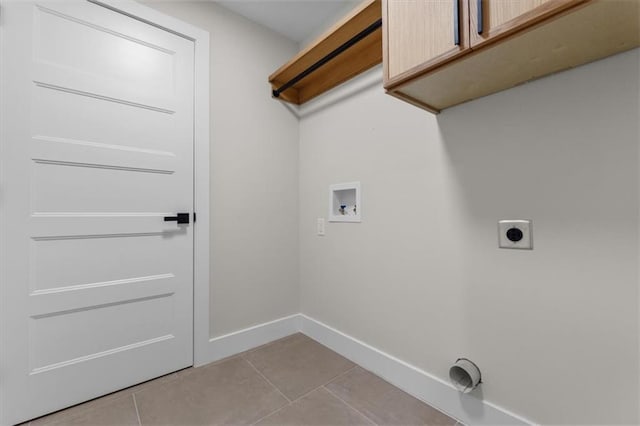 clothes washing area with hookup for an electric dryer, cabinets, light tile patterned floors, and hookup for a washing machine