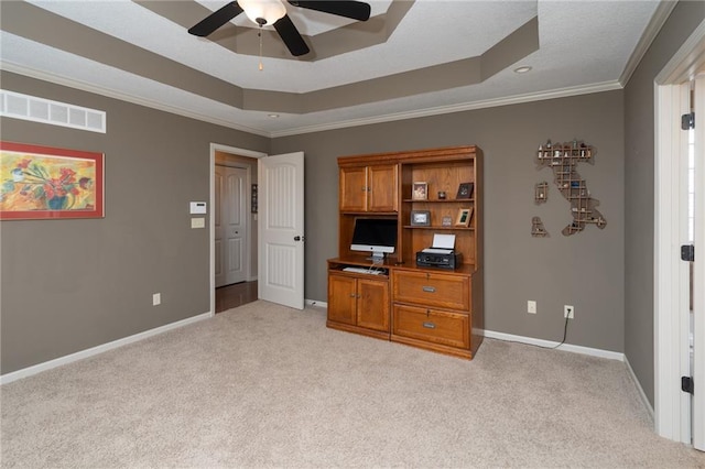 interior space with a raised ceiling, ceiling fan, light colored carpet, and ornamental molding