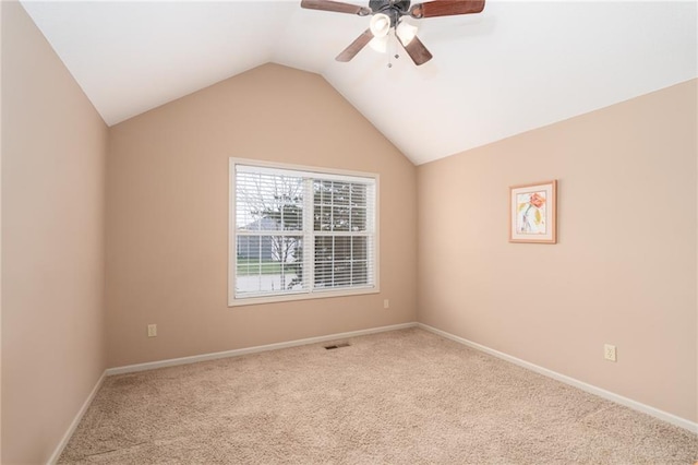 carpeted spare room with ceiling fan and lofted ceiling