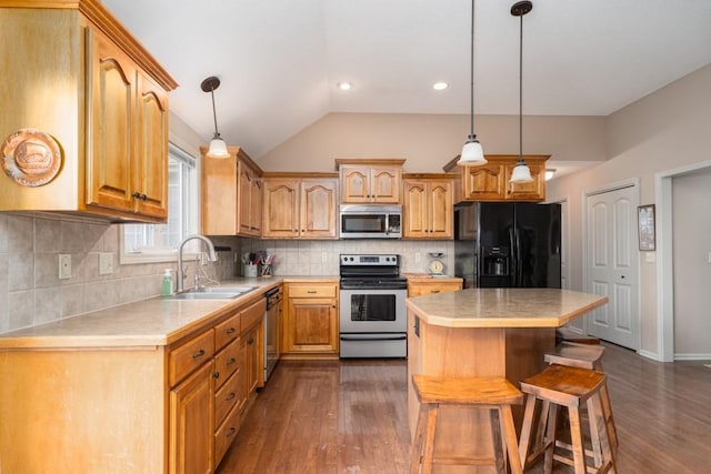 kitchen featuring sink, a center island, hanging light fixtures, dark hardwood / wood-style floors, and appliances with stainless steel finishes