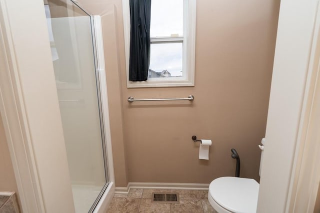 bathroom featuring tile patterned floors, toilet, and walk in shower