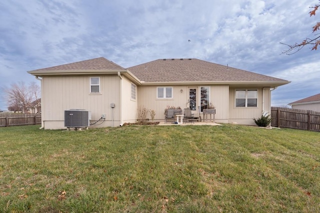 rear view of property with cooling unit, a patio area, and a yard