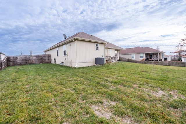 exterior space with central AC unit and a lawn