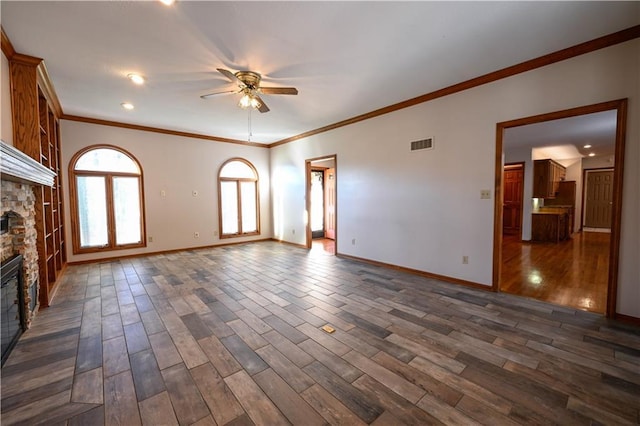 unfurnished living room featuring ceiling fan, crown molding, a fireplace, and dark wood-type flooring