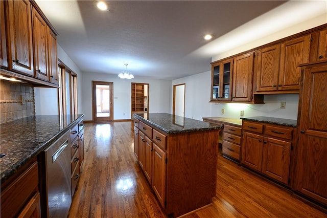 kitchen featuring pendant lighting, dishwasher, dark wood-type flooring, an inviting chandelier, and a kitchen island