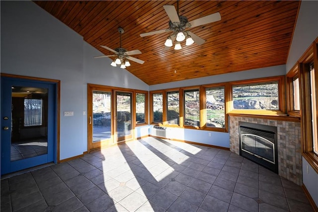 unfurnished living room with wooden ceiling, high vaulted ceiling, dark tile patterned flooring, ceiling fan, and a tiled fireplace