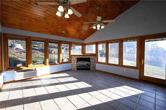 unfurnished sunroom with a tiled fireplace, ceiling fan, plenty of natural light, and vaulted ceiling