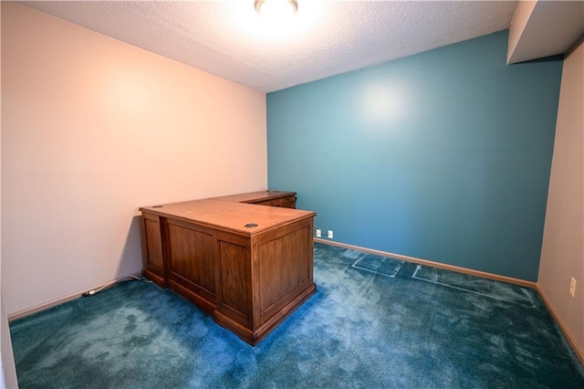 unfurnished office featuring a textured ceiling and dark colored carpet