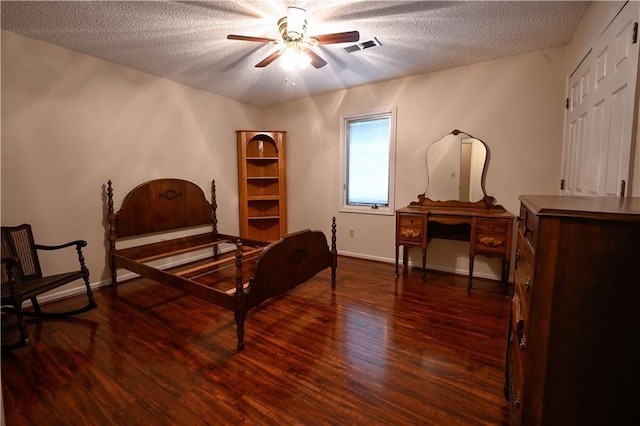 bedroom with ceiling fan, dark wood-type flooring, and a textured ceiling