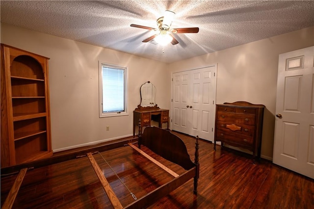 bedroom with ceiling fan, dark hardwood / wood-style flooring, and a textured ceiling