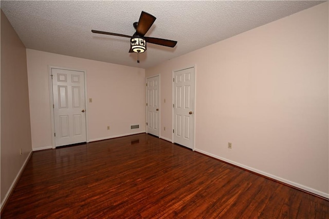 spare room with dark hardwood / wood-style floors, ceiling fan, and a textured ceiling