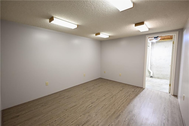 unfurnished room featuring hardwood / wood-style floors and a textured ceiling