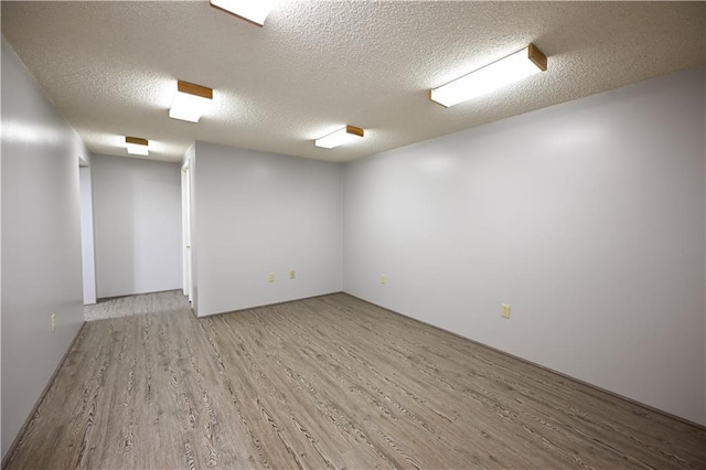 spare room featuring hardwood / wood-style floors and a textured ceiling