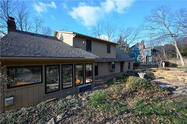 22812 E Bradford Ln, Blue Springs, MO 64015 - rear view of house featuring a shingled roof and a chimney