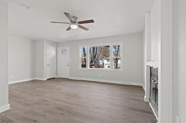 unfurnished living room featuring ceiling fan and light hardwood / wood-style flooring