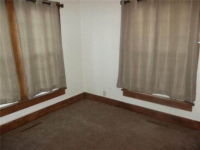 unfurnished room with dark carpet