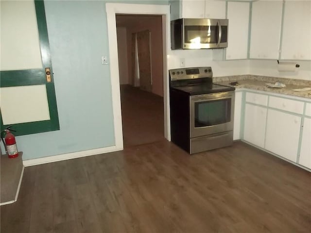 kitchen featuring white cabinetry, stainless steel appliances, and dark hardwood / wood-style floors