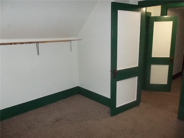 spacious closet with dark carpet and lofted ceiling