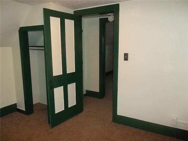 hallway with dark colored carpet