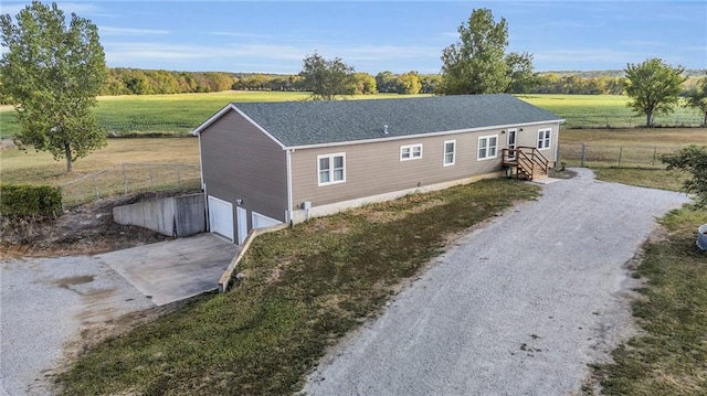 view of property exterior with a rural view and a garage