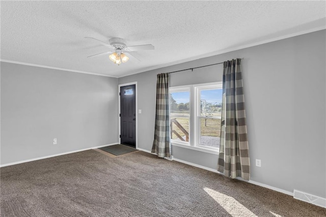 carpeted spare room with ceiling fan, crown molding, and a textured ceiling