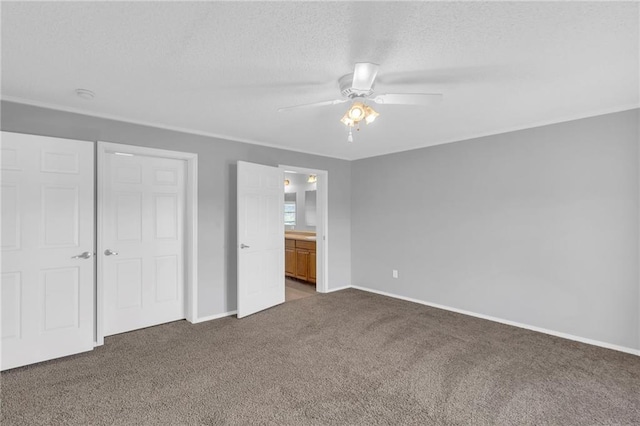 unfurnished bedroom with ceiling fan, ensuite bathroom, carpet floors, a textured ceiling, and a closet