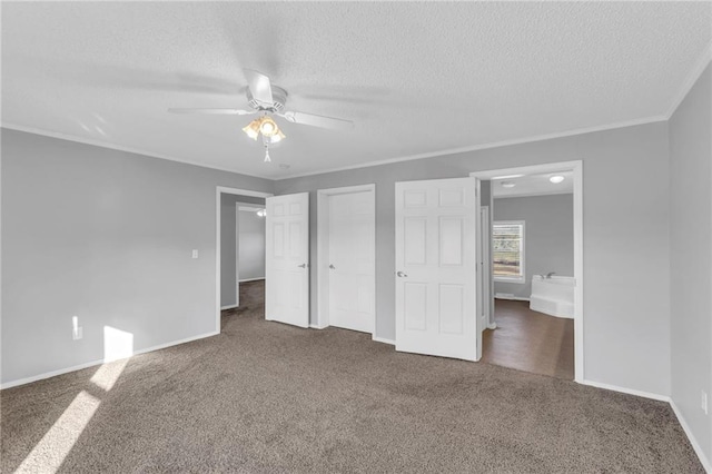 unfurnished bedroom featuring ceiling fan, dark carpet, a textured ceiling, and ornamental molding