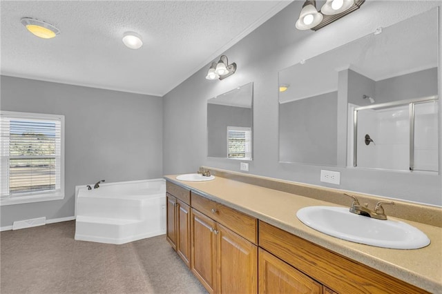 bathroom with vanity, a healthy amount of sunlight, a textured ceiling, and shower with separate bathtub