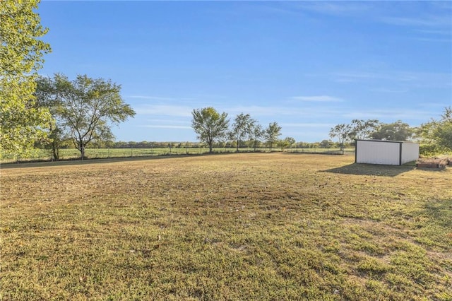 view of yard with an outbuilding and a rural view