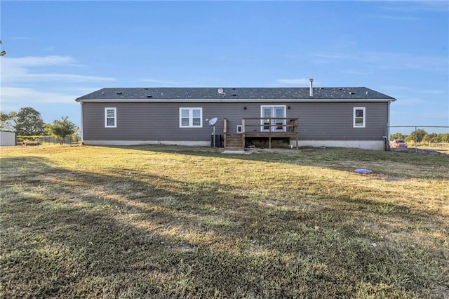 rear view of property with a lawn and a wooden deck