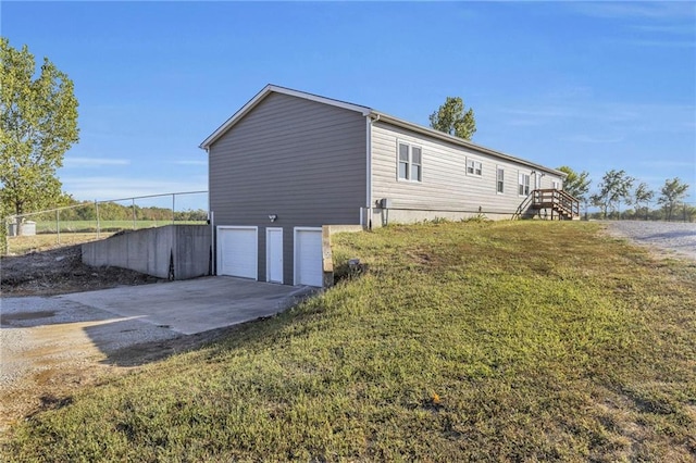 view of side of property with a lawn and a garage