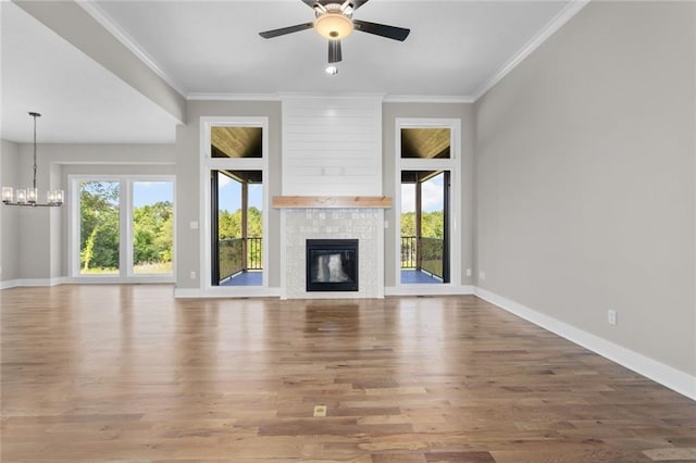 unfurnished living room featuring crown molding, hardwood / wood-style floors, and ceiling fan with notable chandelier