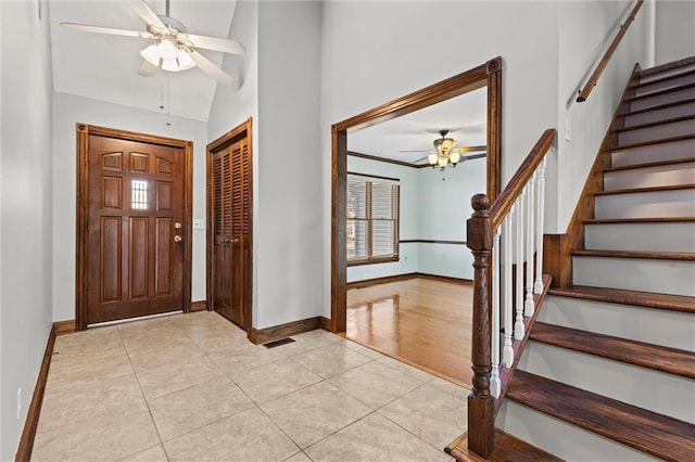 entryway featuring ceiling fan, light tile patterned floors, and vaulted ceiling